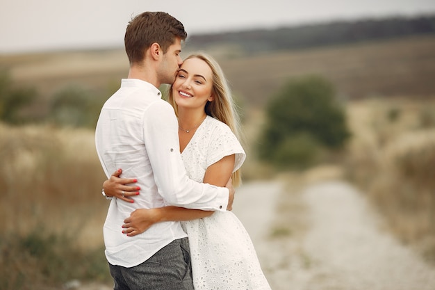 Hermosa pareja pasa tiempo en un campo de otoño