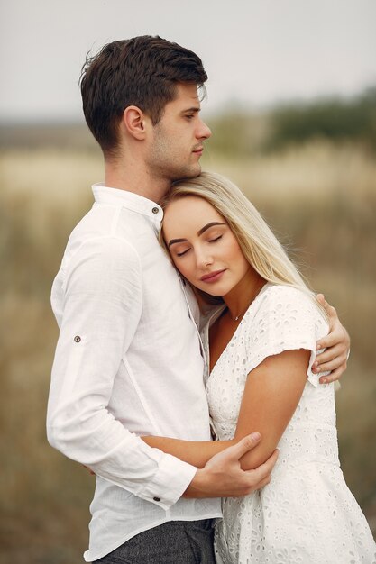 Hermosa pareja pasa tiempo en un campo de otoño