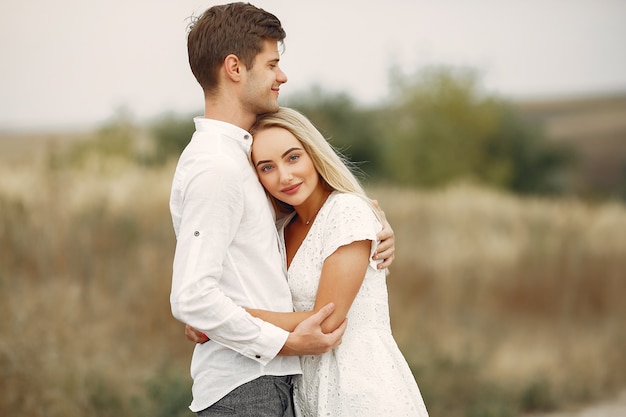 Hermosa pareja pasa tiempo en un campo de otoño