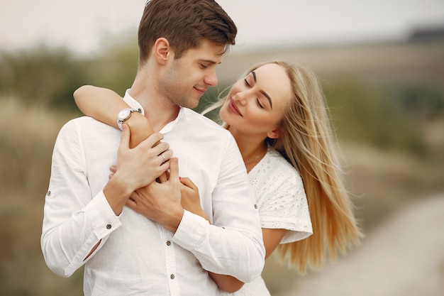 Hermosa pareja pasa tiempo en un campo de otoño