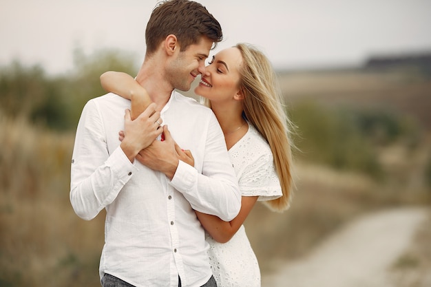 Hermosa pareja pasa tiempo en un campo de otoño