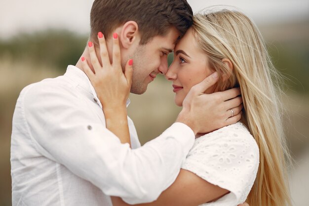 Hermosa pareja pasa tiempo en un campo de otoño