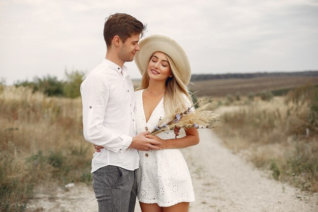 Hermosa pareja pasa tiempo en un campo de otoño