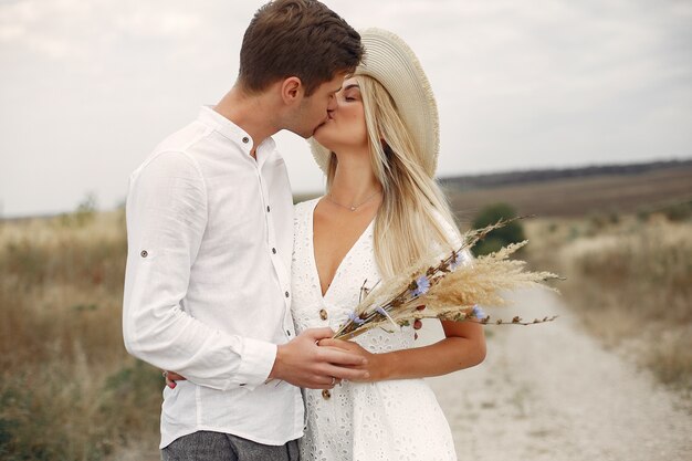 Hermosa pareja pasa tiempo en un campo de otoño