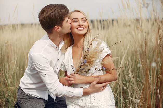 Hermosa pareja pasa tiempo en un campo de otoño