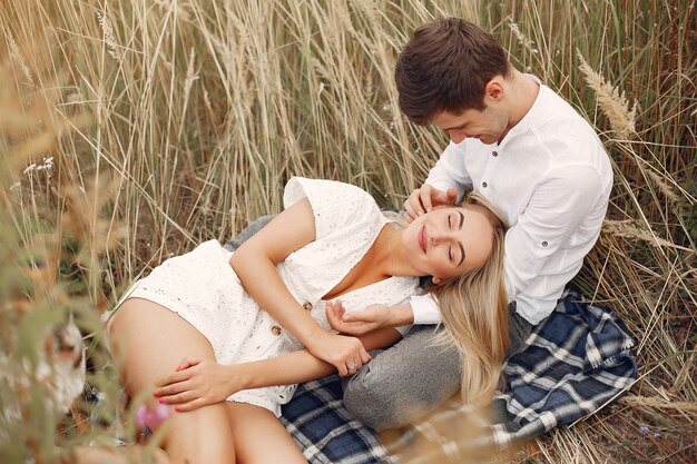 Hermosa pareja pasa tiempo en un campo de otoño