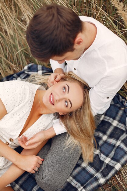 Hermosa pareja pasa tiempo en un campo de otoño