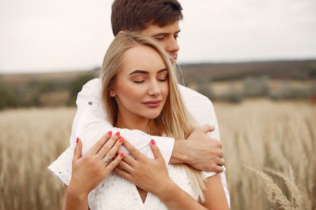 Hermosa pareja pasa tiempo en un campo de otoño