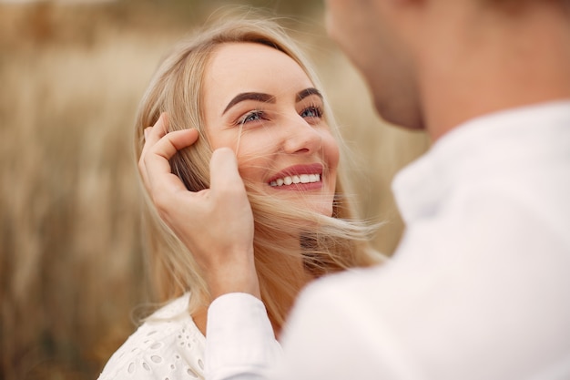 Hermosa pareja pasa tiempo en un campo de otoño