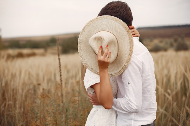 Hermosa pareja pasa tiempo en un campo de otoño