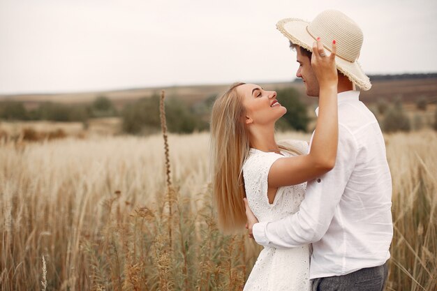 Hermosa pareja pasa tiempo en un campo de otoño