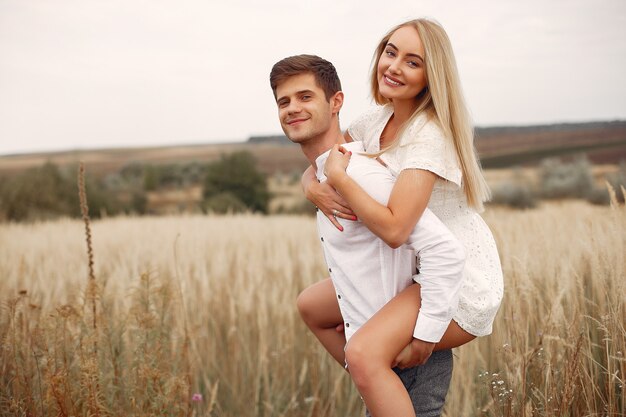 Hermosa pareja pasa tiempo en un campo de otoño