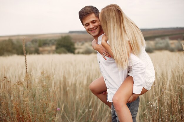 Hermosa pareja pasa tiempo en un campo de otoño