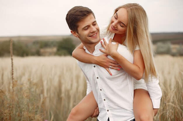 Hermosa pareja pasa tiempo en un campo de otoño