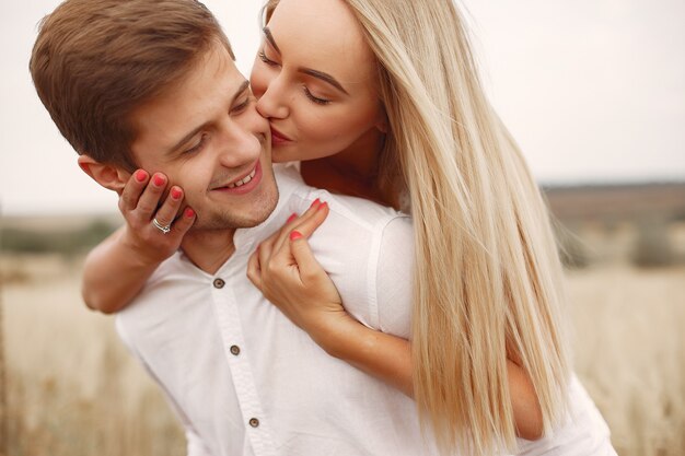 Hermosa pareja pasa tiempo en un campo de otoño