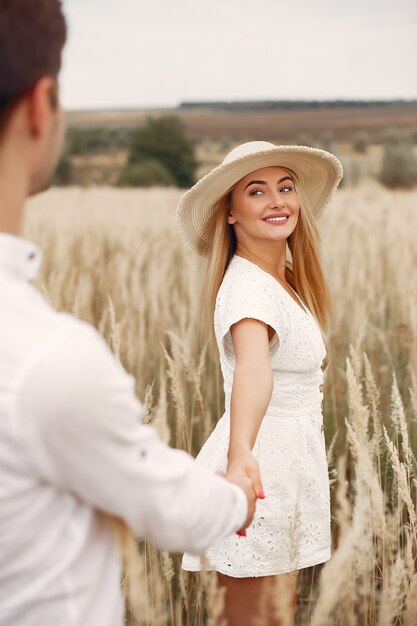 Hermosa pareja pasa tiempo en un campo de otoño