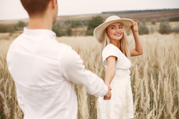 Hermosa pareja pasa tiempo en un campo de otoño