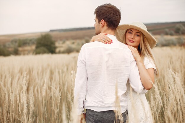 Hermosa pareja pasa tiempo en un campo de otoño