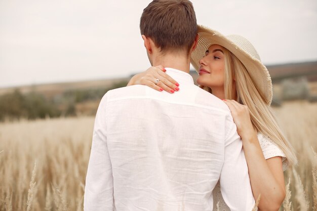 Hermosa pareja pasa tiempo en un campo de otoño