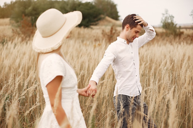 Hermosa pareja pasa tiempo en un campo de otoño