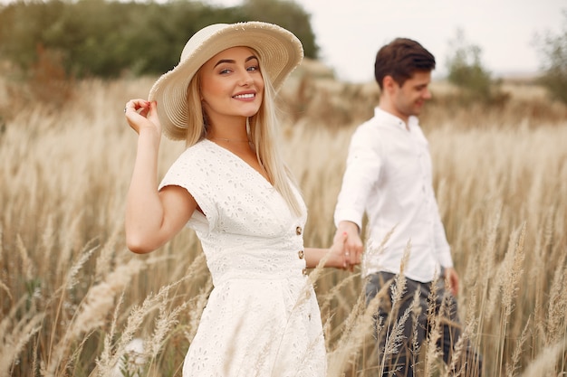 Hermosa pareja pasa tiempo en un campo de otoño