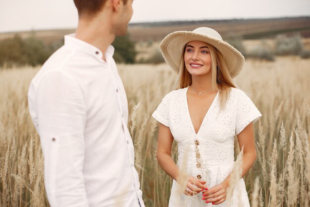 Hermosa pareja pasa tiempo en un campo de otoño