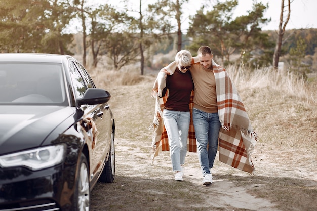 Hermosa pareja pasa tiempo en un campo de otoño