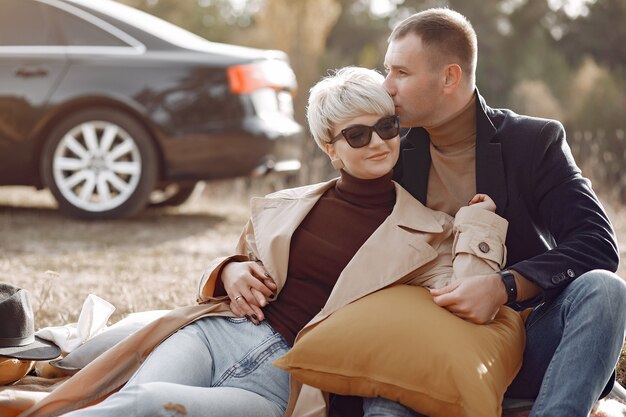 Hermosa pareja pasa tiempo en un campo de otoño