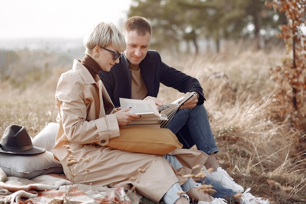 Foto gratuita hermosa pareja pasa tiempo en un campo de otoño