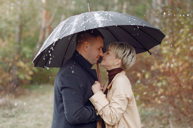 Hermosa pareja pasa tiempo en un campo de otoño