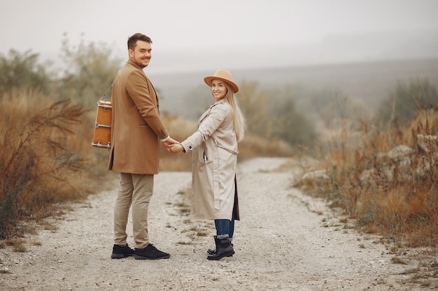 Hermosa pareja pasa tiempo en un campo de otoño