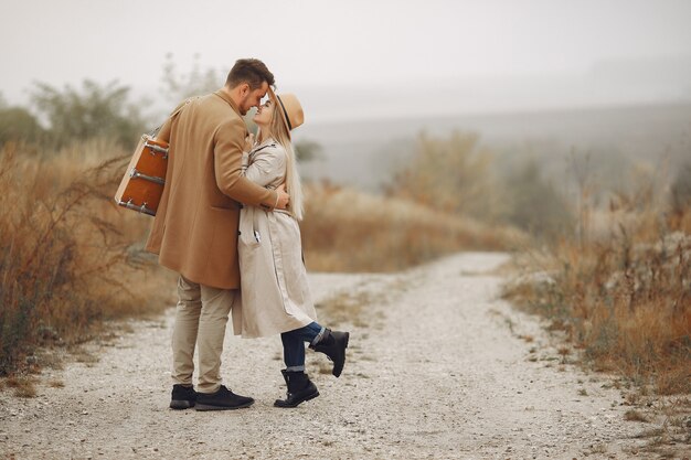 Hermosa pareja pasa tiempo en un campo de otoño