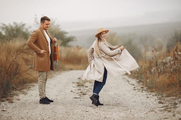 Hermosa pareja pasa tiempo en un campo de otoño