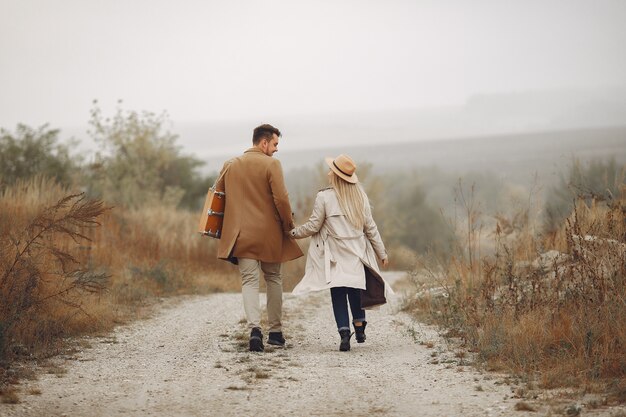 Hermosa pareja pasa tiempo en un campo de otoño