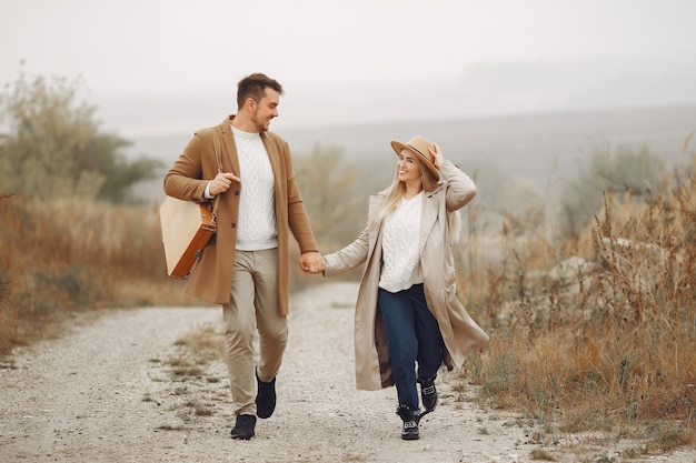 Foto gratuita hermosa pareja pasa tiempo en un campo de otoño