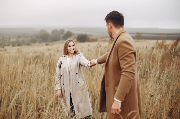 Hermosa pareja pasa tiempo en un campo de otoño