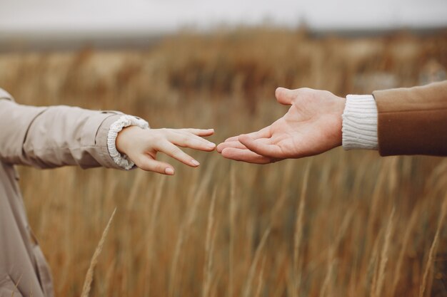 Hermosa pareja pasa tiempo en un campo de otoño