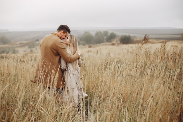 Hermosa pareja pasa tiempo en un campo de otoño