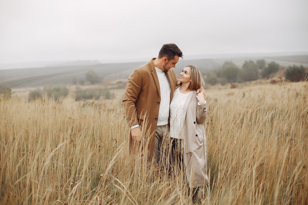 Hermosa pareja pasa tiempo en un campo de otoño