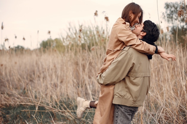 Hermosa pareja pasa tiempo en un campo de otoño