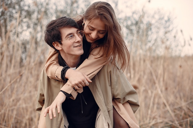 Hermosa pareja pasa tiempo en un campo de otoño