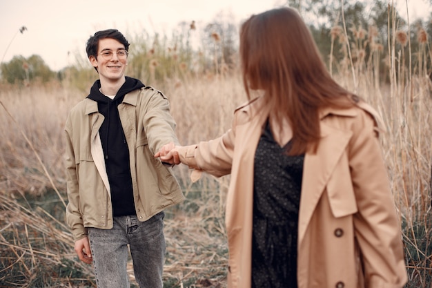 Hermosa pareja pasa tiempo en un campo de otoño