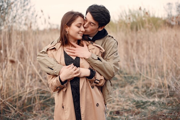 Hermosa pareja pasa tiempo en un campo de otoño