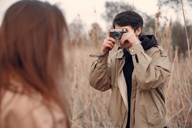 Hermosa pareja pasa tiempo en un campo de otoño