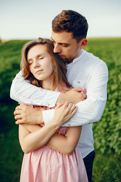 Hermosa pareja pasa tiempo en un campo de verano