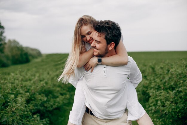 Hermosa pareja pasa tiempo en un campo de verano