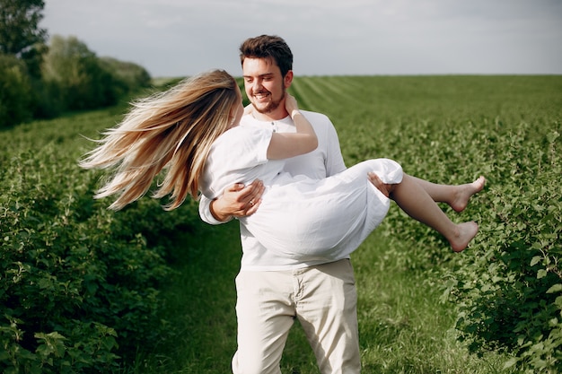 Hermosa pareja pasa tiempo en un campo de verano