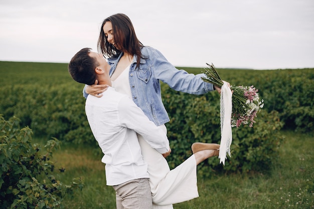 Foto gratuita hermosa pareja pasa tiempo en un campo de verano