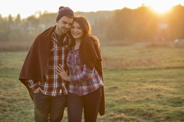 Hermosa pareja pasa tiempo en un parque al atardecer