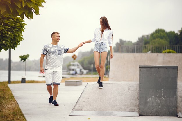 Hermosa pareja pasa tiempo en un parque nublado de otoño